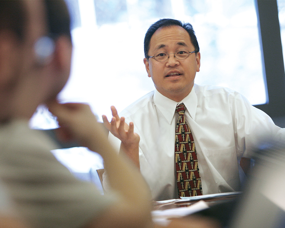 Christopher S. Yoo sitting and talking with students