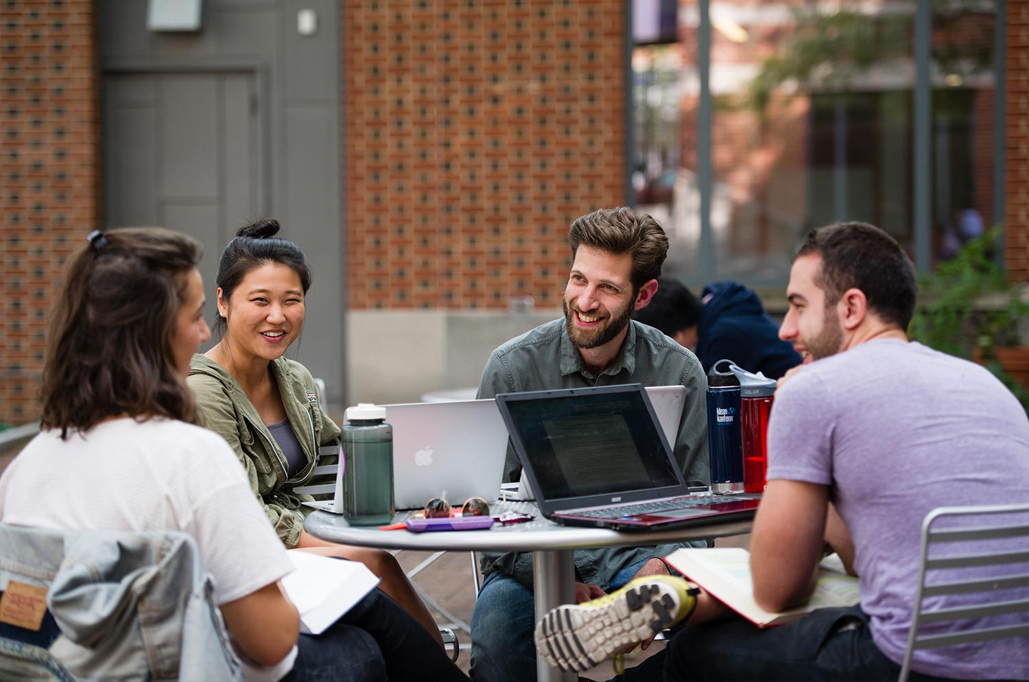 A group of students meeting on an outdoor patio