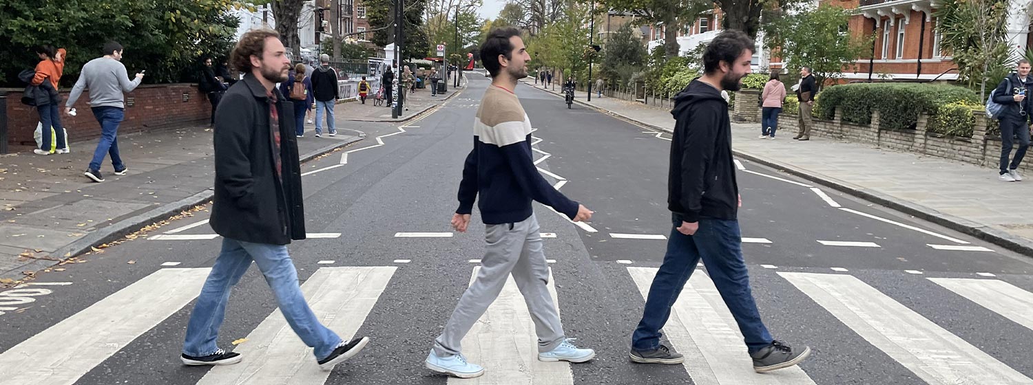 portrait view of three male law students walking across a street, reminiscent of The Beatles Abbey Road studio album cover