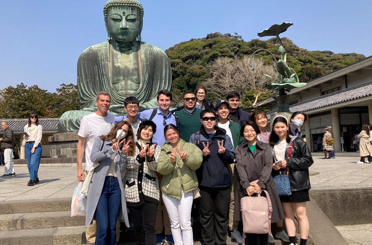 a group of law students travelling abroad take a photo in front of the Great Buddha of Kamakura